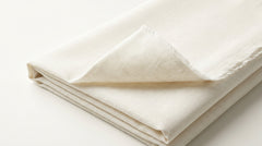 The Ivory Dusk — folded fabric yardage showing luminous off-white weave