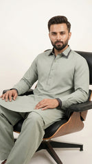 The Pista Green — seated lifestyle shot showing contrast cuffs and full silhouette