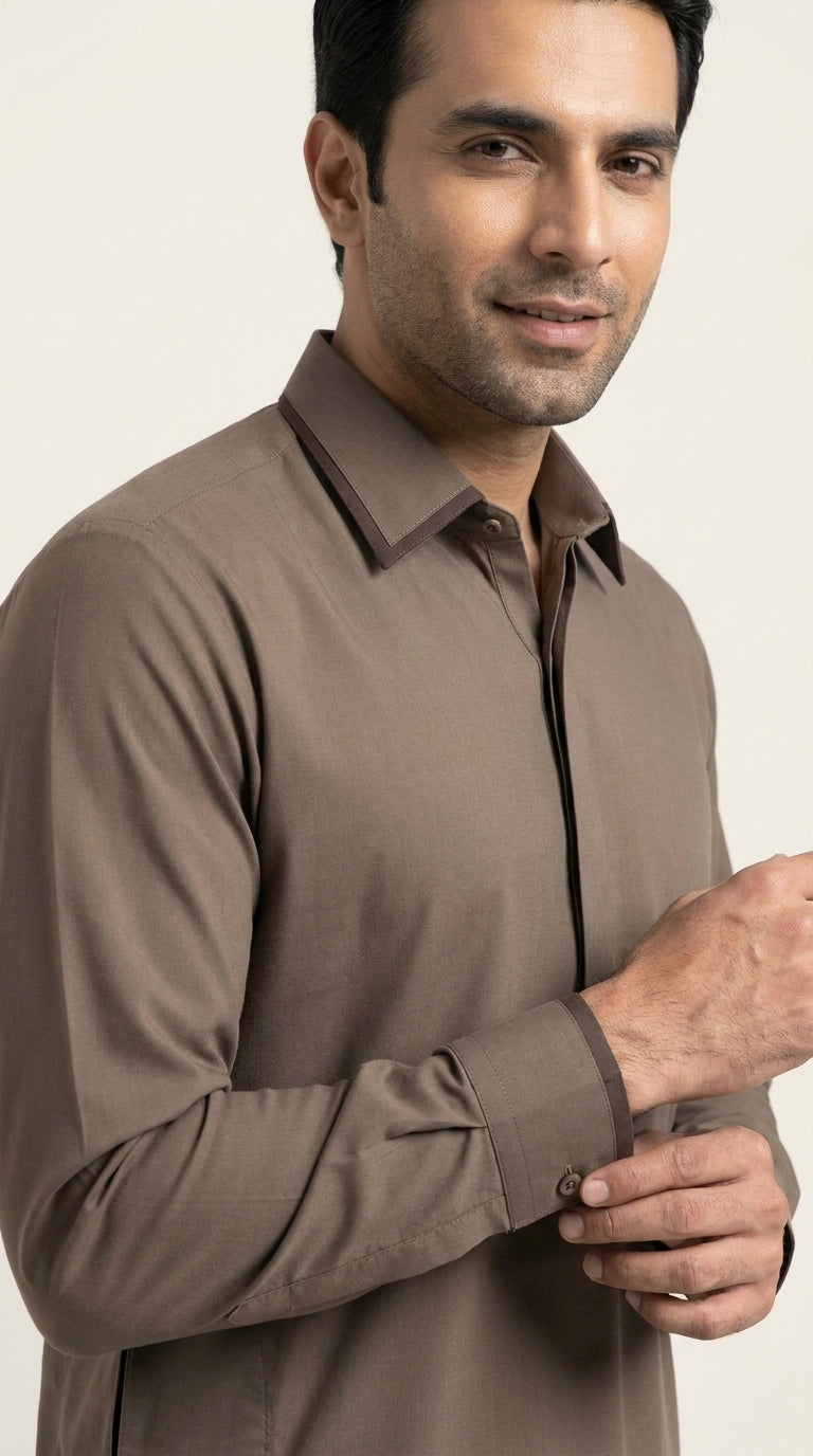 The Muted Earth — seated lifestyle shot styled as kurta shalwar