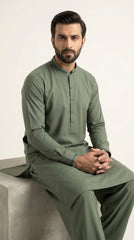 The Pista Green — seated lifestyle shot with hands clasped