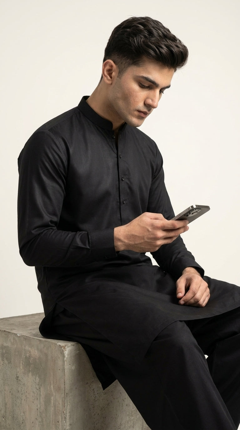 The Jet Black — seated lifestyle shot with phone